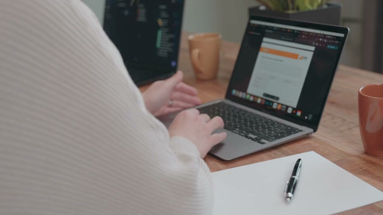 Über die Schulter gesehen: Zwei Personen gehen am Laptop gemeinsam einen Entwurf durch