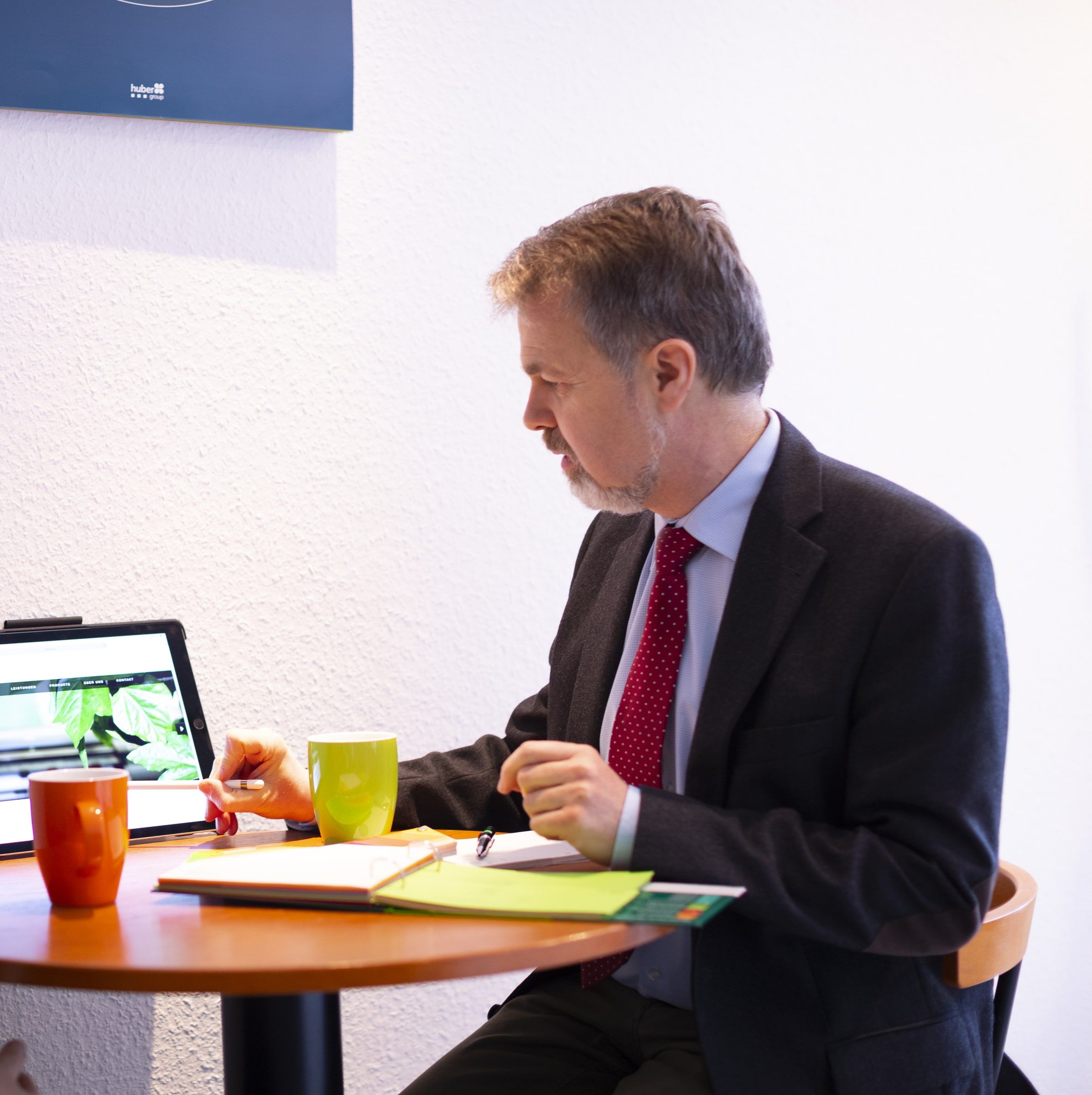 Bernhard Luthe im Beratungsgespräch am Tisch, vor ihm ein Tablet mit einem Entwurf