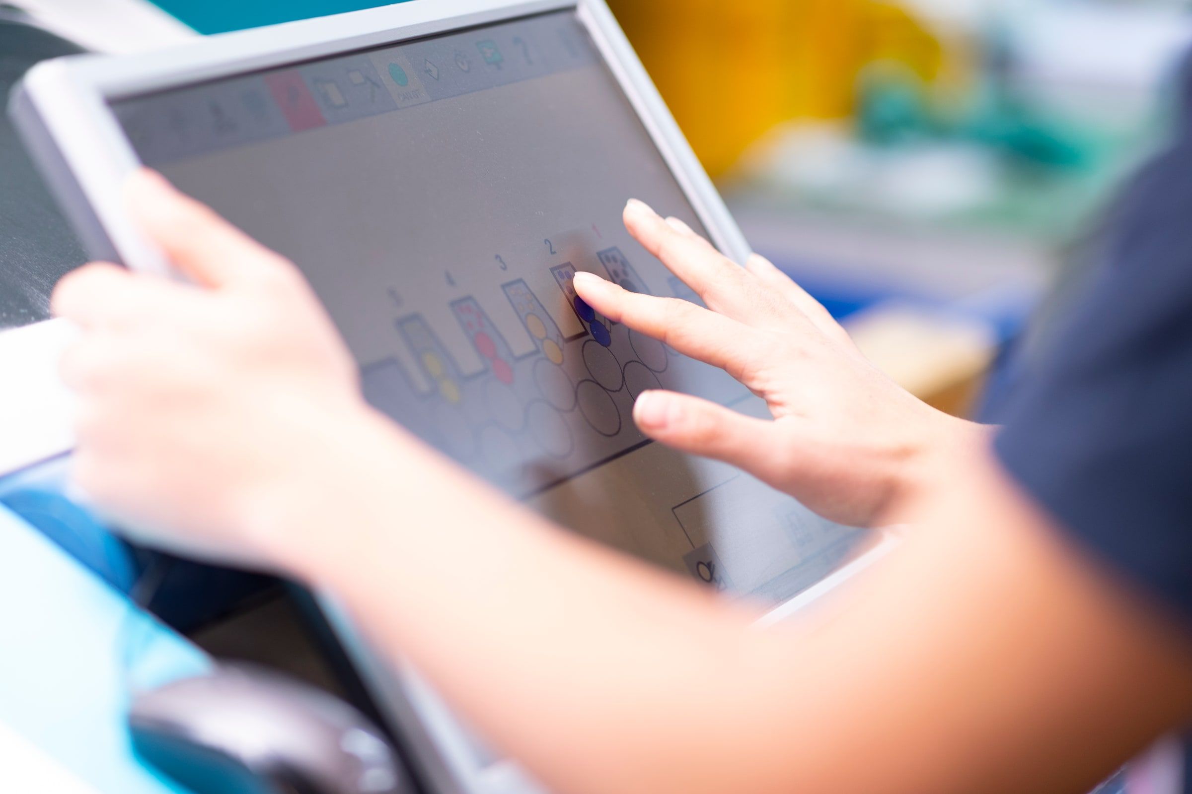 Hände am Touchscreen des Leitstands einer Offsetmaschine